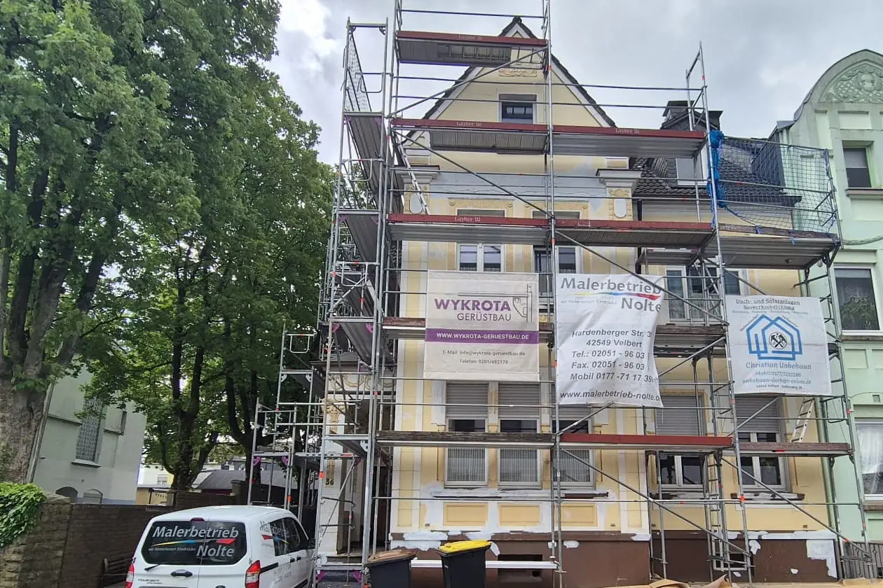 Das Gründerzeithaus eingerüstet, mit vergilbter Altfassade