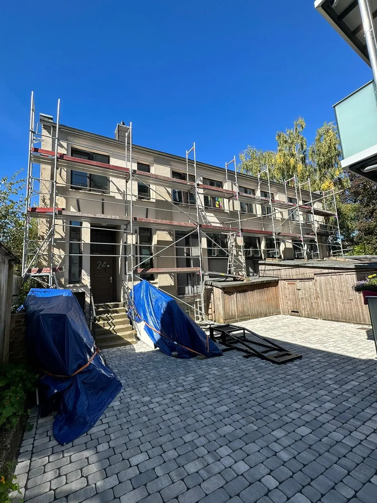 Das Hofhaus eingerüstet, alter Putz, blaue Planen im Hof