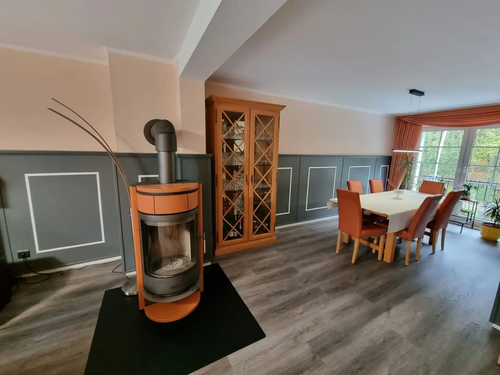 Fertig gestrichenes Esszimmer: Wand in Apricot, graugrüne Vertäfelung mit weißen Zierrahmen