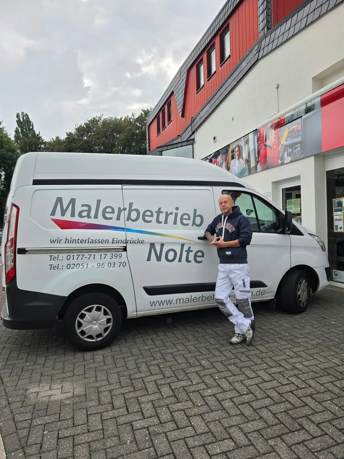 Jens Nolte, Inhaber des Malerbetriebs Nolte, vor seinem beschrifteten Firmenwagen