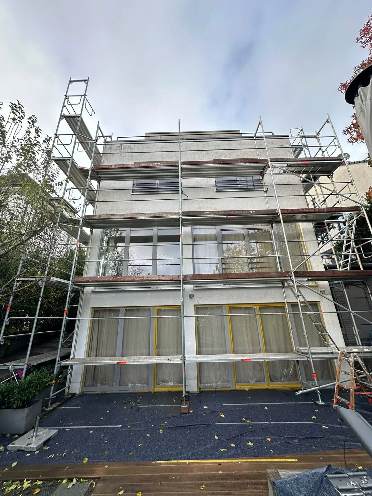 Das Stadthaus eingerüstet, grauer Altputz, Fenster foliert